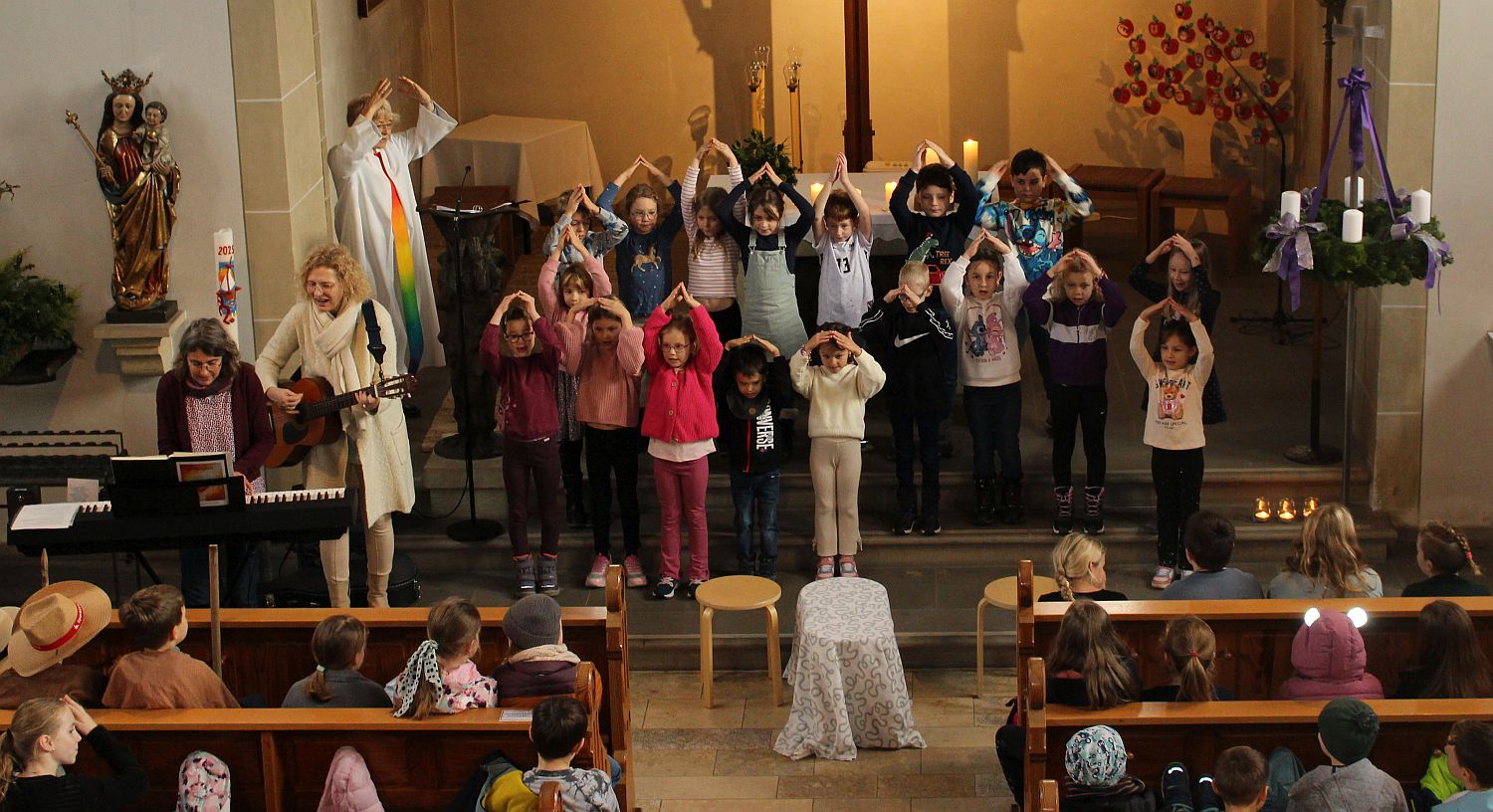 Foto von der Empore der Kirche aus, vorne am Altar stehen singende Kinder